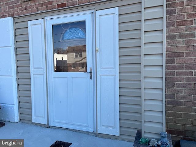 view of exterior entry with brick siding