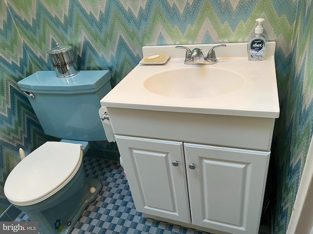 bathroom featuring tile patterned flooring, toilet, vanity, and wallpapered walls