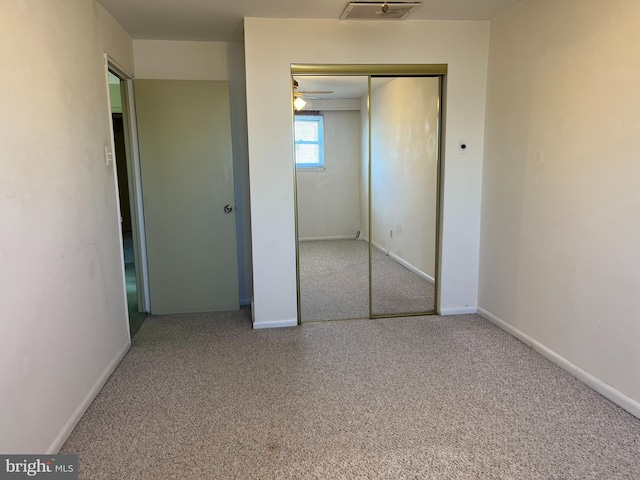 unfurnished bedroom with visible vents, baseboards, a closet, and carpet flooring