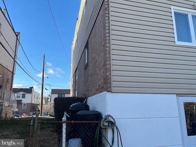 view of side of property with fence and brick siding