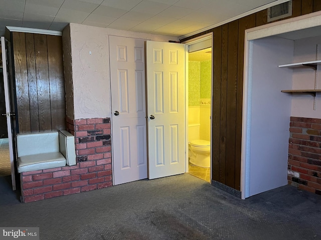 unfurnished bedroom featuring carpet flooring, connected bathroom, and visible vents