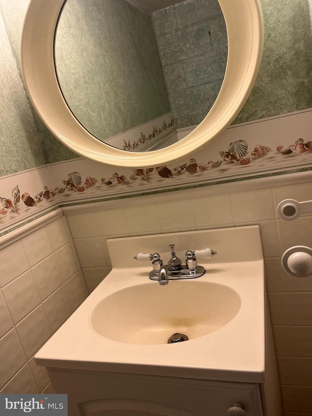 bathroom with vanity and tile walls