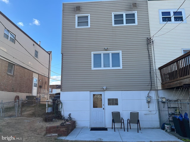 back of property featuring a patio and fence