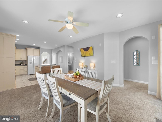 carpeted dining space with ceiling fan