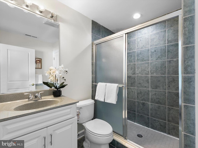 bathroom featuring vanity, toilet, and walk in shower