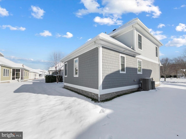 view of snowy exterior with central AC unit