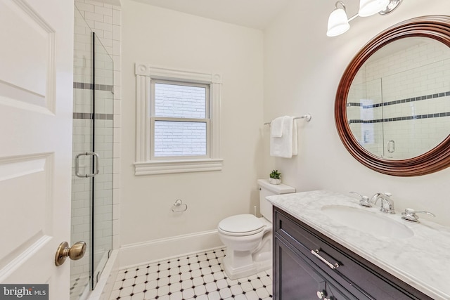 bathroom with toilet, a shower with shower door, and vanity