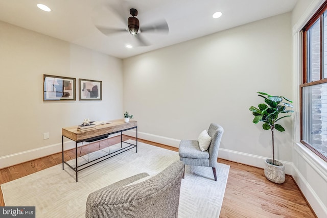 home office with light hardwood / wood-style floors and ceiling fan