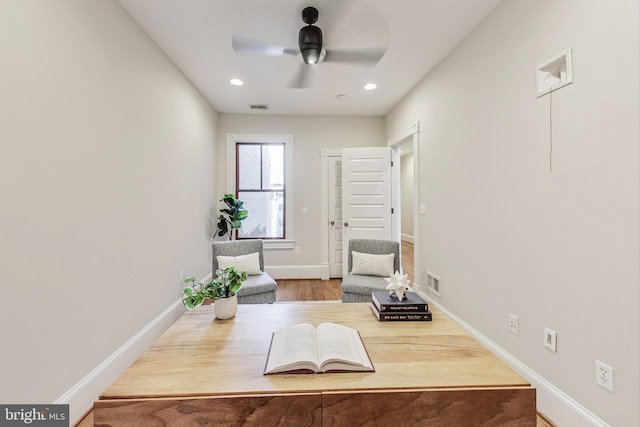 sitting room featuring ceiling fan and hardwood / wood-style floors