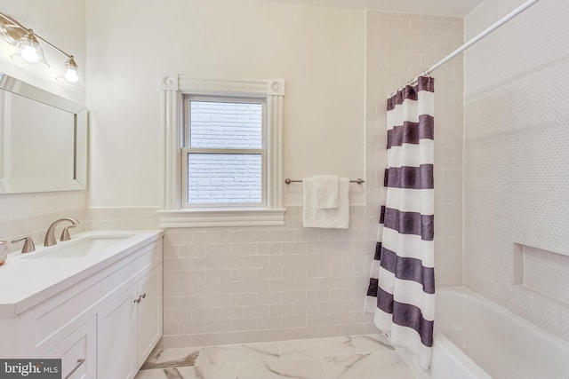 bathroom with vanity, tile walls, and shower / bath combo with shower curtain