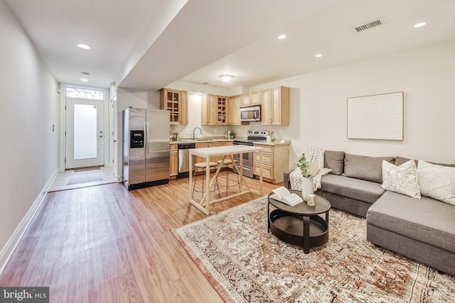 living room with sink and light wood-type flooring