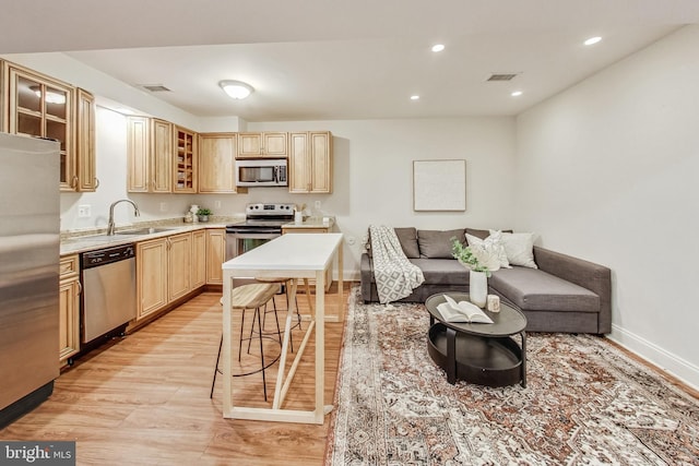 kitchen featuring sink, light wood-type flooring, light brown cabinetry, and appliances with stainless steel finishes