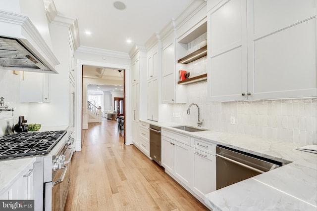 kitchen with premium range hood, white cabinetry, light stone counters, and sink