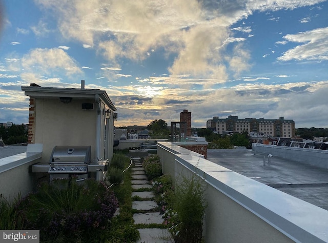 balcony at dusk featuring area for grilling