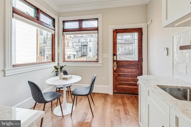 dining space featuring light hardwood / wood-style flooring and ornamental molding