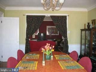 dining area with an inviting chandelier and ornamental molding