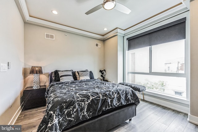 bedroom featuring ceiling fan, crown molding, and hardwood / wood-style flooring