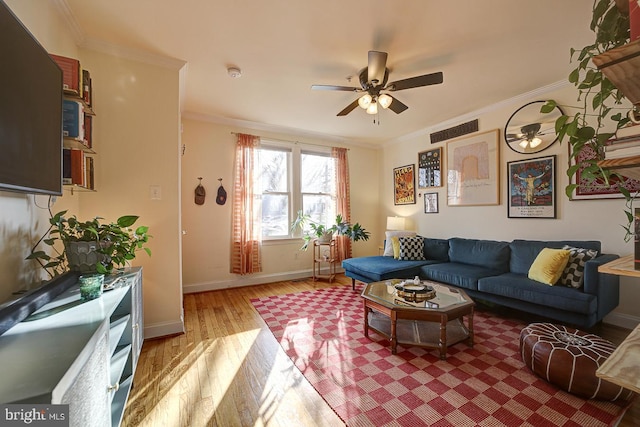 living room with ceiling fan, light wood-type flooring, and crown molding