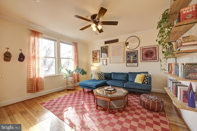 living room featuring hardwood / wood-style flooring, ceiling fan, and ornamental molding