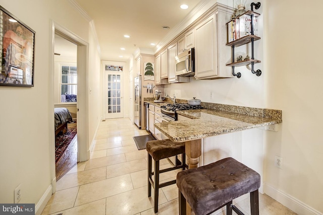 kitchen with a breakfast bar, light stone countertops, light tile patterned floors, kitchen peninsula, and stainless steel appliances