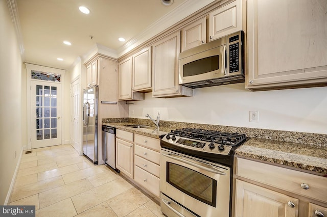 kitchen featuring sink, light brown cabinets, stainless steel appliances, light stone counters, and light tile patterned floors