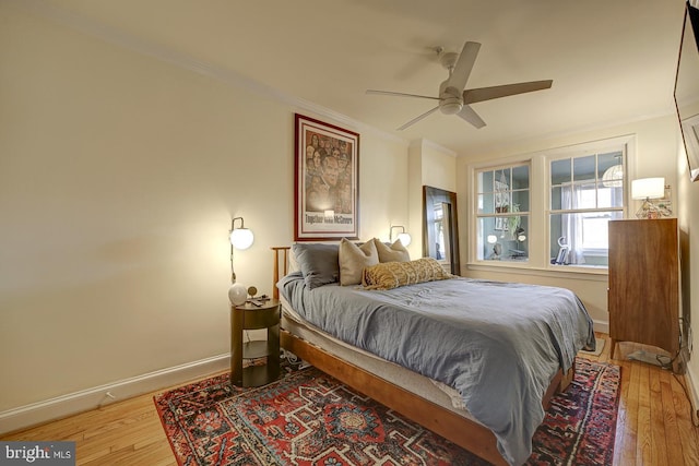 bedroom with wood-type flooring, ceiling fan, and crown molding