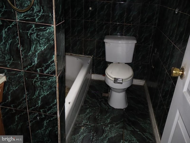 bathroom with a bath and tile walls