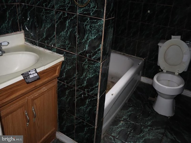 bathroom featuring vanity, toilet, tile walls, and a washtub