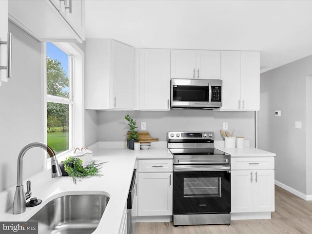 kitchen with sink, white cabinets, and stainless steel appliances