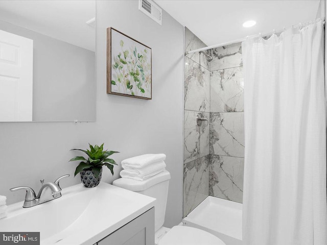 bathroom featuring toilet, vanity, and a shower with shower curtain