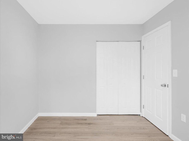 unfurnished bedroom featuring a closet and light hardwood / wood-style floors