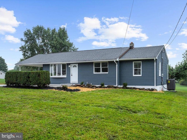 ranch-style home featuring cooling unit and a front lawn