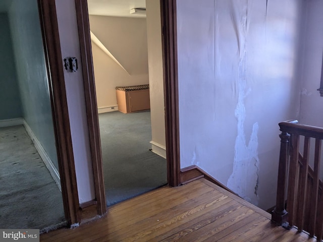 corridor featuring wood-type flooring and a baseboard heating unit