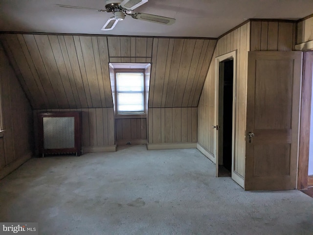 bonus room with ceiling fan, light colored carpet, lofted ceiling, and wooden walls