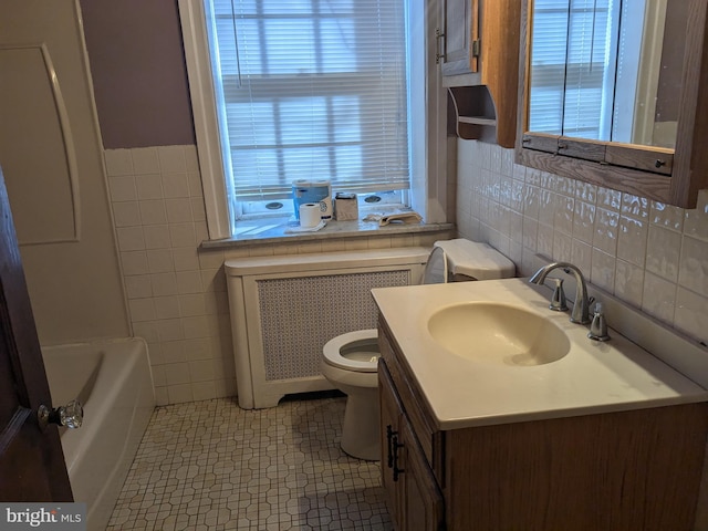 full bathroom featuring radiator heating unit, tile patterned floors, toilet, vanity, and tile walls