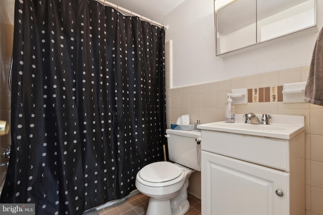 bathroom with sink, a shower with curtain, tile patterned flooring, toilet, and tile walls