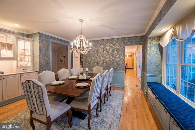 dining space featuring crown molding, a chandelier, and light wood-type flooring