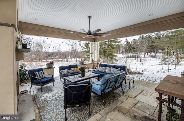 snow covered patio with an outdoor living space and ceiling fan