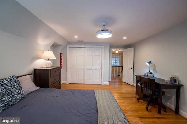 bedroom with light hardwood / wood-style floors and a closet