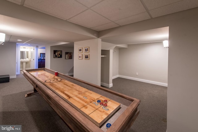 playroom featuring a paneled ceiling and dark carpet