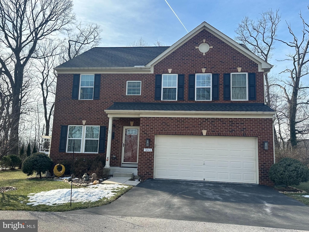 view of front of property featuring a garage, aphalt driveway, and brick siding