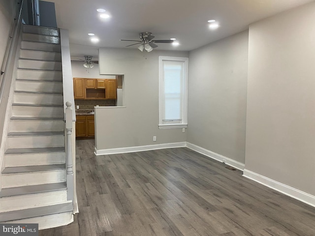 unfurnished living room with dark hardwood / wood-style floors and ceiling fan