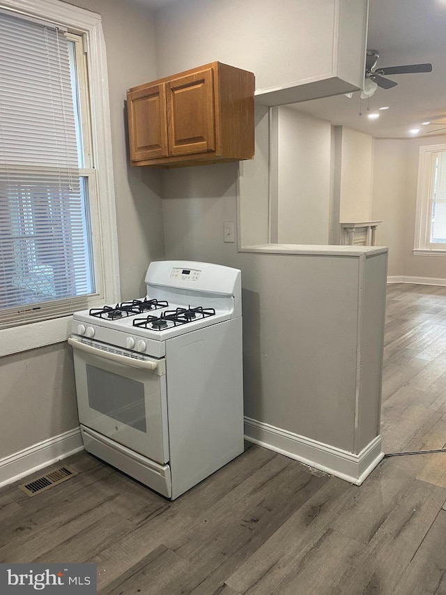 kitchen featuring ceiling fan, wood-type flooring, and white gas range oven