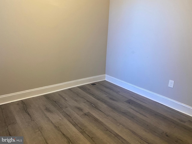 spare room featuring dark hardwood / wood-style flooring