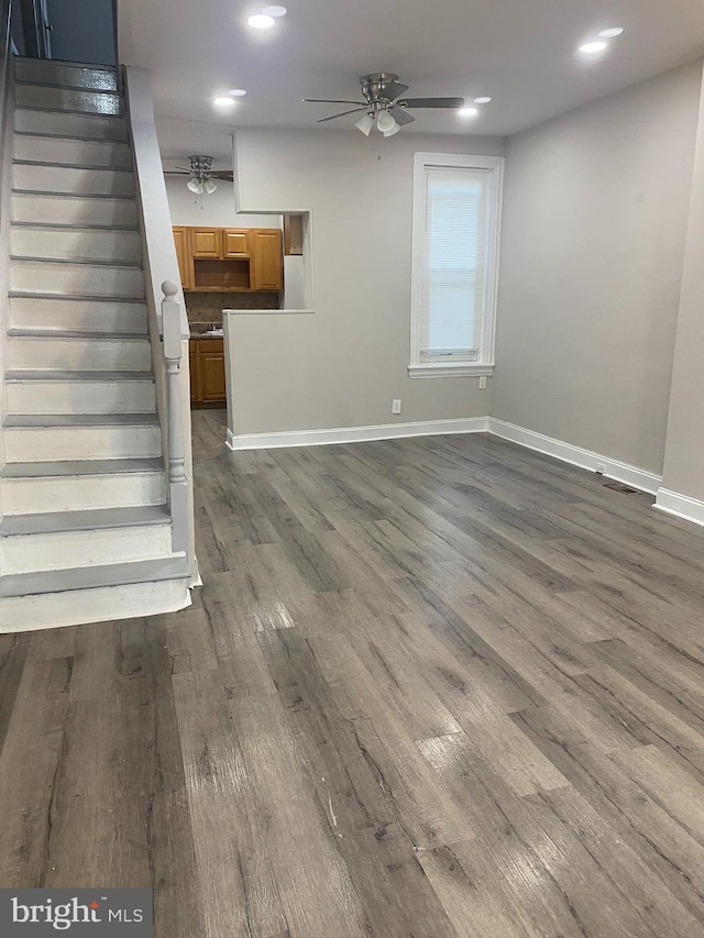 unfurnished living room with ceiling fan and dark hardwood / wood-style floors