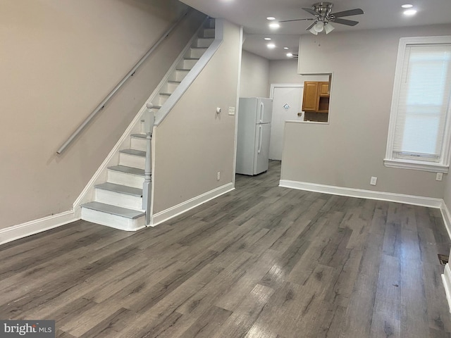 unfurnished living room with ceiling fan and dark wood-type flooring