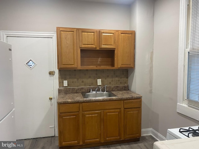 kitchen with dark hardwood / wood-style flooring, tasteful backsplash, white refrigerator, and sink