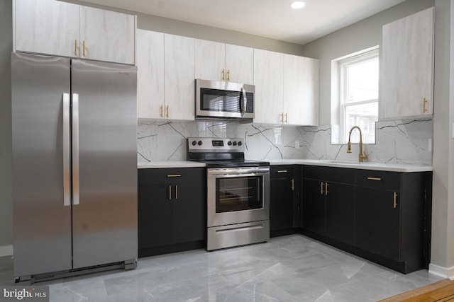 kitchen with tasteful backsplash, light brown cabinetry, sink, and appliances with stainless steel finishes