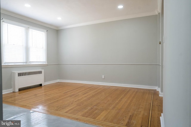 spare room featuring radiator heating unit, hardwood / wood-style flooring, and crown molding