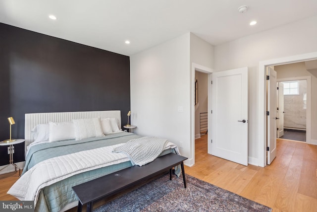 bedroom featuring connected bathroom and hardwood / wood-style floors